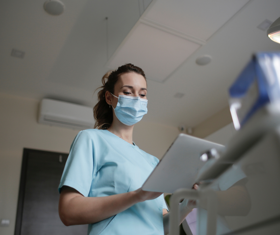 Image of a female healthcare worker wearing light blue scrubs and a mask