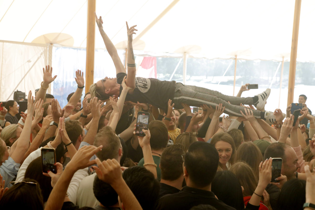 Image of singer crowdsurfing inside a tent