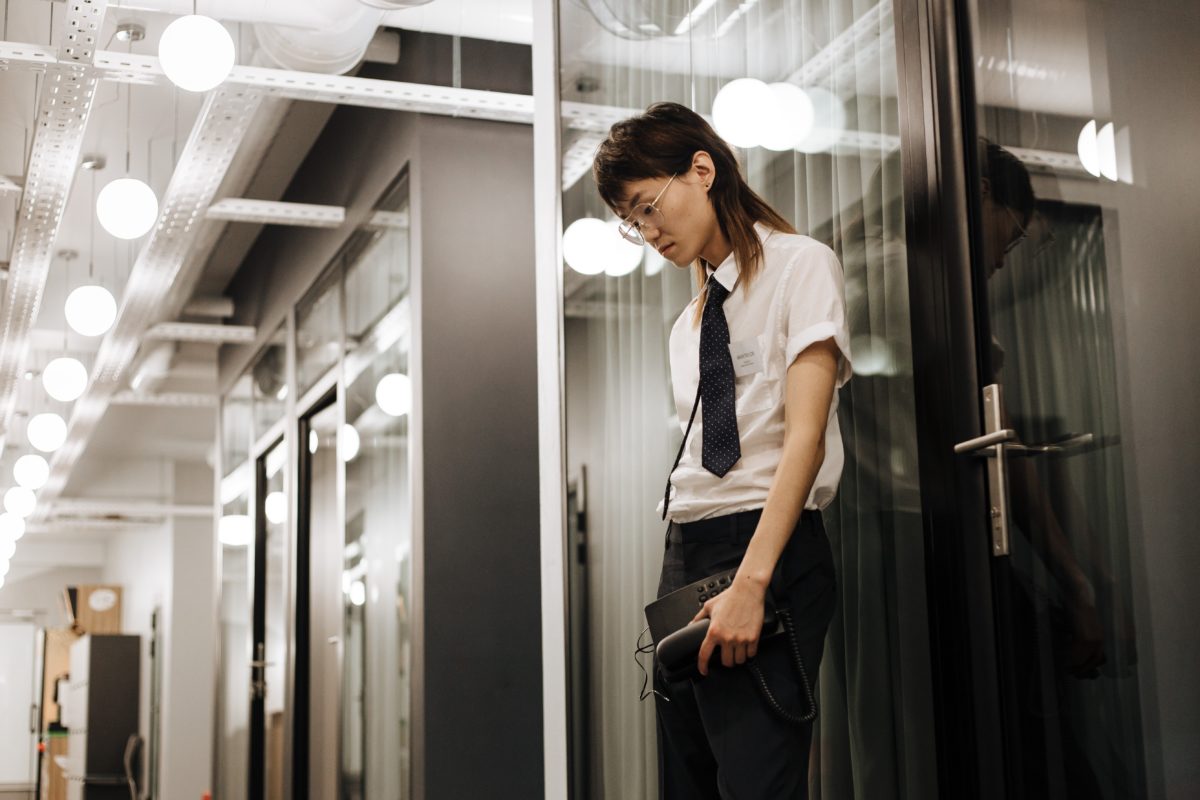 Image of a young worker standing in a hallway looking sad