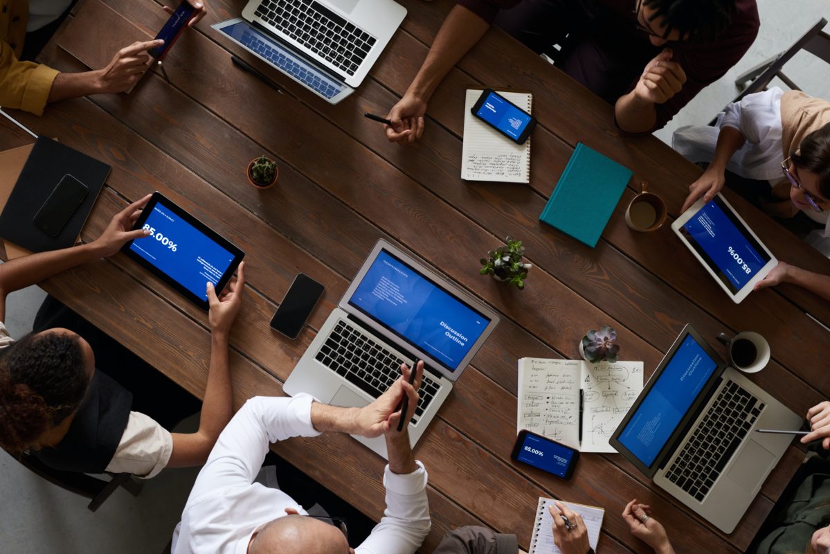 Bird's eye view of a meeting table. people have their laptops out.