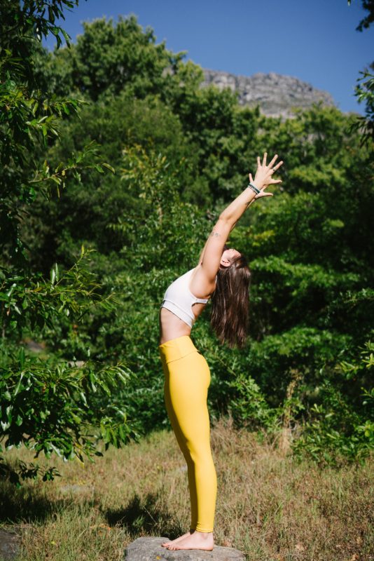 Image of woman in yellow leggings doing yoga outside